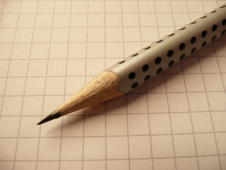Crayon posé sur un cahier à petits carreaux, pour les exercices de grammaire